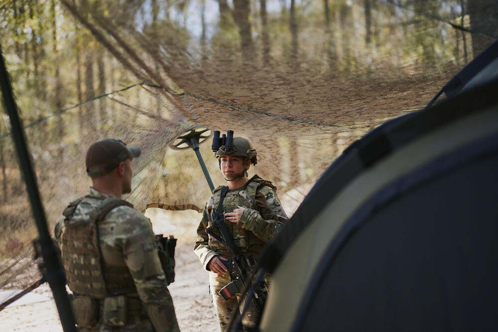 Two field operators walking through autumn woodland