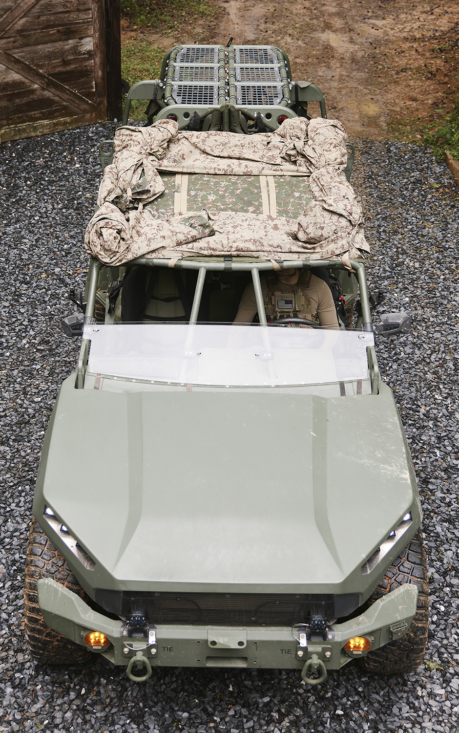 Field operator in camouflage among trees