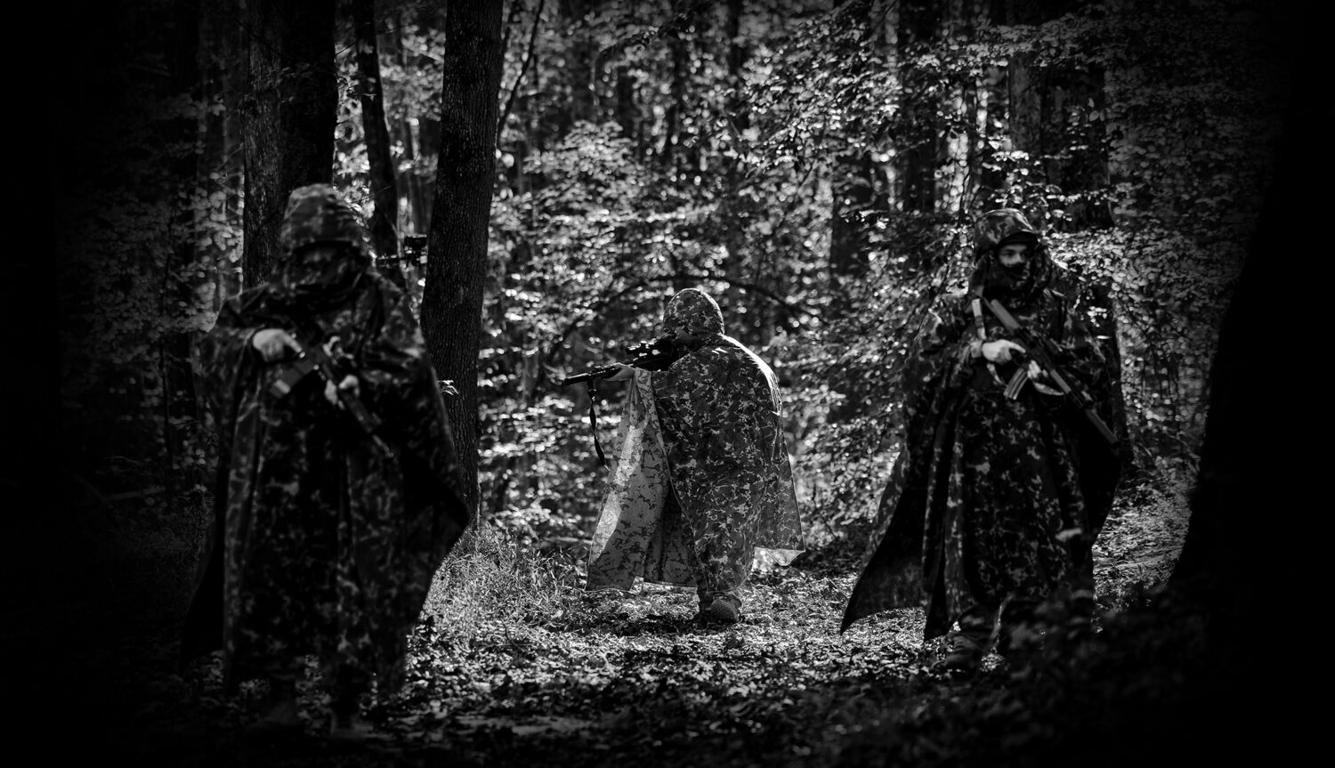Camouflaged field operator moving through a forest