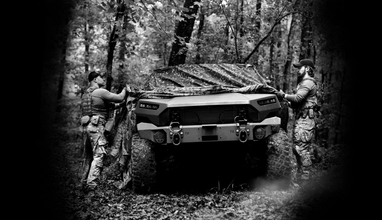 Field operator in camouflage among trees